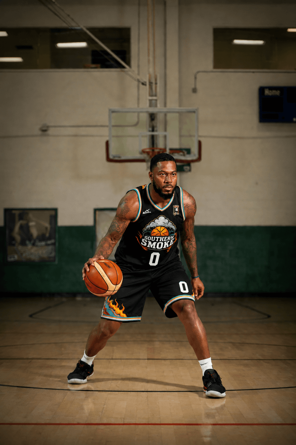 Muscular man in black Southern Smoke jersey dribbles a basketball on an indoor court.